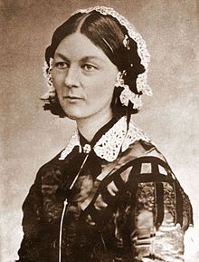 an old black and white photo of a woman wearing a lace headband with her hands on her hips