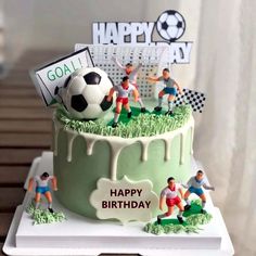 a soccer themed birthday cake with figurines on top