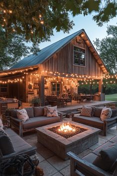 a fire pit sitting in the middle of a patio surrounded by furniture and string lights