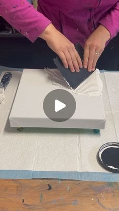 a woman is cutting paper on top of a table