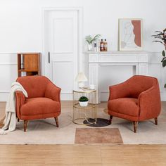 two orange chairs sitting next to each other in a living room