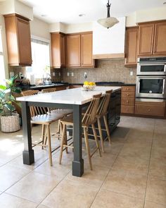 a large kitchen with wooden cabinets and an island table in the middle of the room