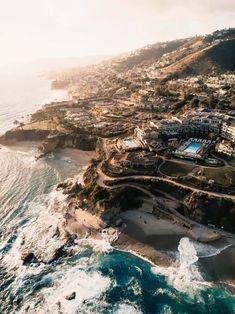 an aerial view of the ocean and coastline with houses on it's sides,