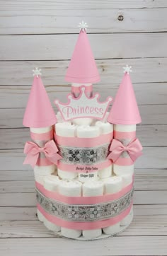 a pink princess diaper cake with lots of diapers on top and a tiara