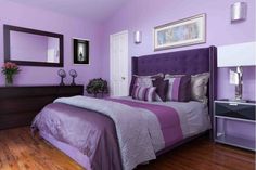 a bedroom with purple walls and wooden floors