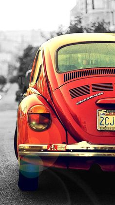 an old red car is parked on the street