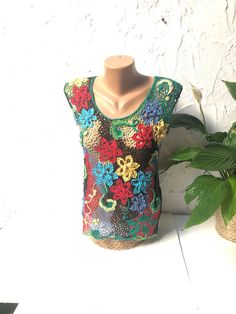 This beautiful sleeveless crochet blouse is handcrafted. The intricate design and attention to detail took a long time to create, resulting in a truly unique and one-of-a-kind piece. This blouse is perfect for any occasion, whether dressed up with a skirt or dressed down with jeans. Measurements:     Chest: 32,3 inches/82 cm     Length: 22,8 inches/58 cm Bohemian Cotton Crochet Tank Top, Multicolor Sleeveless Crochet Dress With Crochet Trim, Multicolor Crochet Lace Sleeveless Dress, Multicolor Sleeveless Crochet Lace Dress, Green Lace Bohemian Tops, Green Bohemian Lace Tops, Green Sleeveless Crochet Top With Crochet Trim, Handmade Lace Crochet Dress, Handmade Multicolor Tops For Spring