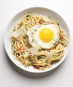 a white plate topped with pasta and an egg