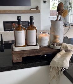 a bathroom counter with two bottles and a brush on it next to a soap dispenser