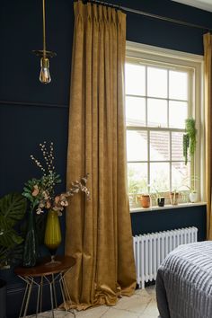 a bedroom with blue walls and yellow curtains