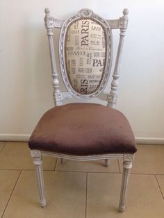 a white chair with a brown cushion on top of it and a wall in the background