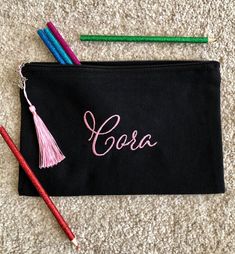 two pencils and a black bag with the word sara on it