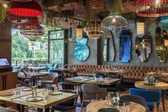 the interior of a restaurant with tables, chairs and lamps hanging from the ceiling above