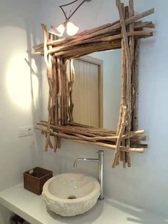 a bathroom sink made out of driftwood in front of a mirror that is hanging on the wall