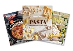 three cookbooks are shown on top of each other, one is filled with pasta