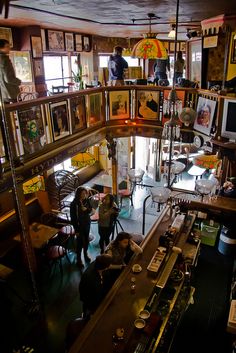 people are standing in a room with many pictures on the walls and shelves above them