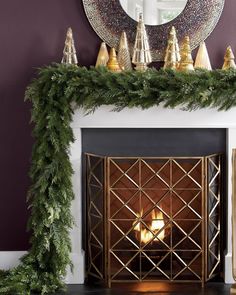 a fireplace with a mirror above it and christmas decorations on the mantel over it