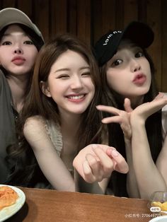 three girls posing for the camera at a restaurant