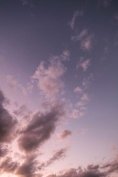 an airplane is flying in the sky at sunset