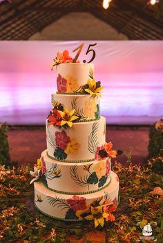 a three tiered cake with flowers on the top and number five on the bottom