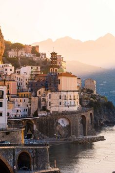 the city is next to an ocean with mountains in the backgrouds and buildings on either side