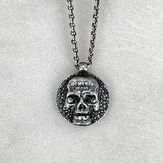 "The Memento Mori Pendant is not just a piece of jewellery; it is a talisman of empowerment and introspection. By wearing this pendant, you carry a symbol of your own mortality, inviting reflection and inspiring a deeper appreciation for the fleeting beauty of life. It serves as a reminder to live fully, embracing the joys and challenges that come your way. Disc measures 1.3cm in diameter. Available on a selection of chain lengths. Picture shows 16\" / 18\" chain. Material : 925 Sterling Silver. Gothic Sterling Silver Jewelry With Skull Print, Halloween Engraved Skull Ring Gift, Symbolic Skull Jewelry With Oxidized Finish, Spiritual Engraved Skull Jewelry, Vintage Skull Print Jewelry Gift, Vintage Skull Print Jewelry As Gift, Vintage Skull Print Jewelry For Gift, Gothic Hand-cast Skull Jewelry, Gothic Jewelry With Skull Print For Gift