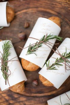 four rolls wrapped in paper with rosemary on them