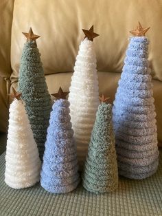 crocheted christmas trees sitting on top of a couch