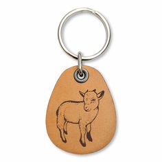 a brown leather key chain with a sheep engraved on the front and back of it