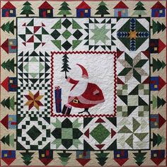 a quilted wall hanging with a santa clause holding a christmas tree on it's back