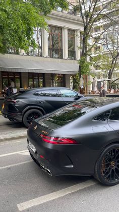 two black sports cars parked on the street