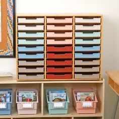 several bins are stacked on top of each other in front of a book shelf