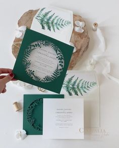 the wedding stationery is green and white with fern leaves on it, as well as an envelope