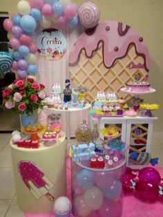 an ice cream parlor decorated with balloons, cake and other items for the dessert table