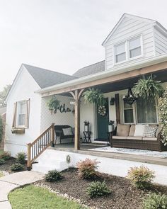 the front porch is decorated with potted plants and wicker furniture, along with an outdoor seating area