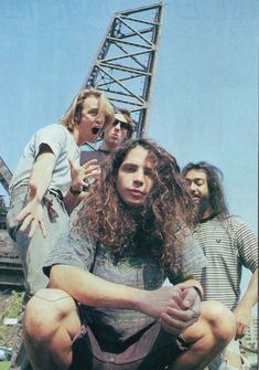 four people sitting on the ground with one person holding something