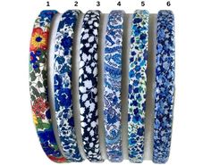 four different bracelets with flowers on them, all in different colors and sizes are shown