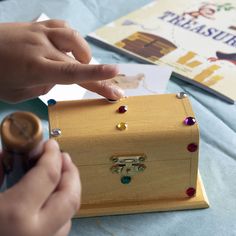 a person is making something out of a wooden box with beads on the inside and outside