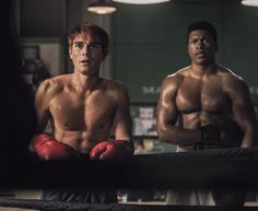 two men standing next to each other with boxing gloves on