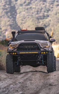 the front end of a toyota truck on a dirt road