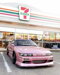 a pink car parked in front of a store