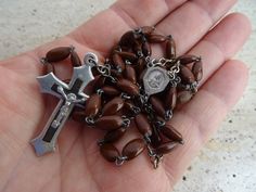 Antique religious catholic rosary with brown beads made from the Spina Christi seed from the well known shrub, thought to have made Christ's crown of thorns of Holy Virgin Mary of Carmel and Holy Christ with cross Holy Christ. This is a nice rosary with 53 'Hail Mary' beads and 6 beads for 'Our Father' ). The length of the circle of rosary is 33,2 inches ( 84 cm). The length of the rosary center with the cross is 6,8 inches ( 17 cm ) I bought the rosary on a brocante ( fleamarket ) in France. I Brown Cross-shaped Rosary With Wooden Beads, Spiritual Brown Rosary Bracelet With Cross, Brown Wooden Beaded Cross Rosary, Handmade Brown Crucifix Rosary, Brown Cross Rosary In Spiritual Style, Brown Rosary With 8mm Beads And Cross Shape, Brown Rosary With 8mm Beads, Brown Spiritual Rosary With Cross, Brown Cross-shaped Spiritual Rosary