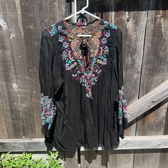 Black Peasant Top With Detailed Floral Embroidery On Front And Arms. Ties In The Front. Im Excellent Condition. Please No Low Offers. Black Blouse With Intricate Embroidery For Festival, Black V-neck Blouse With Floral Embroidery, Black Tops With Intricate Embroidery For Festival, Black Top With Intricate Embroidery For Festival, Black Bohemian Blouse With Embroidered Sleeves, Black Top With Intricate Embroidery, Black Bohemian Top With Embroidered Neckline, Black Long Sleeve Top With Intricate Embroidery, Black Bohemian Blouse With Intricate Embroidery