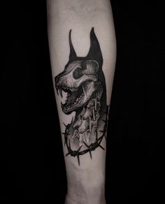 a tattoo on the arm of a person with a dog's head and barbed wire