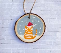 a wooden ornament with an orange cat on it's back hanging from a rope