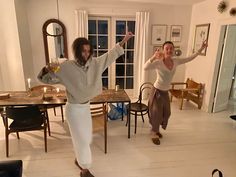 two people are dancing in the living room