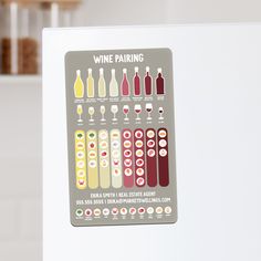 a white refrigerator with some wine bottles and glasses on the door handle, labeled wine pairing