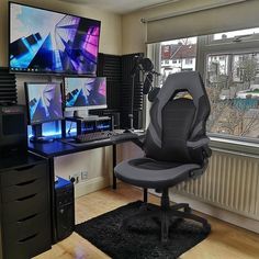 a computer desk with two monitors and a red gaming chair in front of the monitor