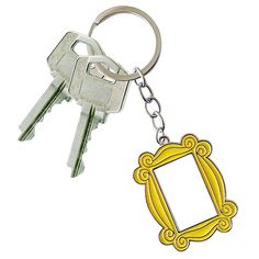 two keys are attached to a keychain that is shaped like an ornate frame