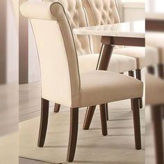 a dining room table and chairs with white upholstered backrests on them